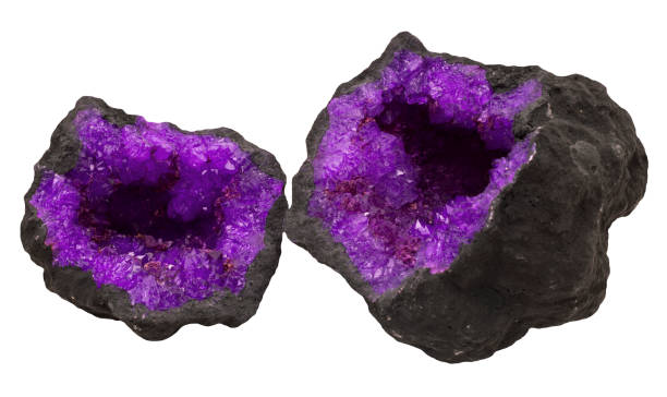 Two halves of a dark geode revealing vibrant purple Amethyst crystals.