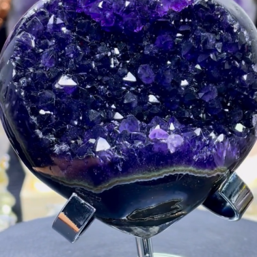 Museum-quality AAA heart shaped Uruguayan amethyst geode named Midnight Heart, featuring deeply saturated imperial purple crystals and polished agate edges on a metal stand, specimen 12.