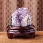 One-of-a-kind deep purple amethyst cave with a horizontal almond-shaped eye cavity and thick agate banding on a custom wood stand, specimen number 10