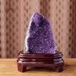 One-of-a-kind deep purple amethyst cave with a shield-like open face and thick agate border on a custom wood stand, specimen number 3