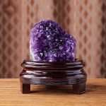 One-of-a-kind petite egg-shaped deep purple amethyst cave with thick rock matrix on a custom wood stand, specimen number 8