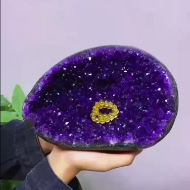 One-of-a-kind 15.4 lb standless amethyst treasure basin known as the Violet Nest, featuring a deep bowl shape with ink-purple crystals and a crystal bracelet resting inside