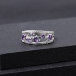 Luxury Amethyst and Sapphire Ring placed on a black textured jewelry display, capturing the brilliant internal fire and contrast of the natural sapphires and amethysts.