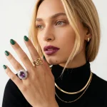 Model wearing The Empress High-End Amethyst Ring on a dark velvet background, demonstrating its powerful royal statement and substantial scale on hand.