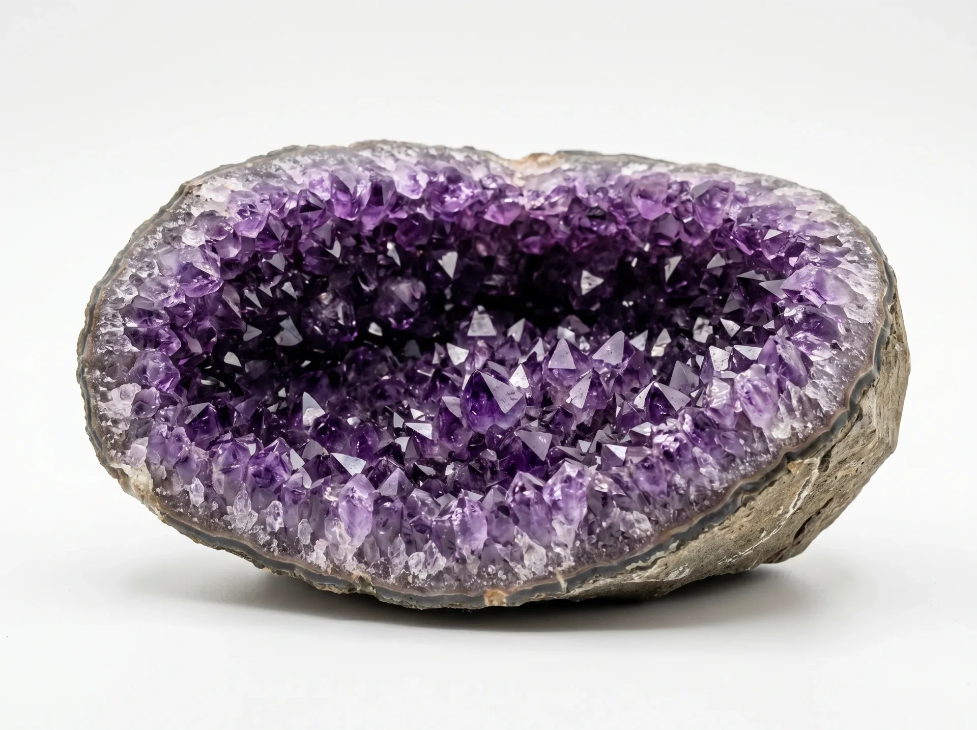 amethyst geode buying guide—deep purple Brazilian geode split open on white surface—crystal interior detail