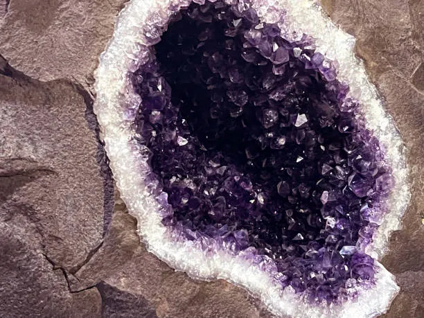 amethyst geode cave cross section—volcanic cavity lined with purple crystal points—natural formation