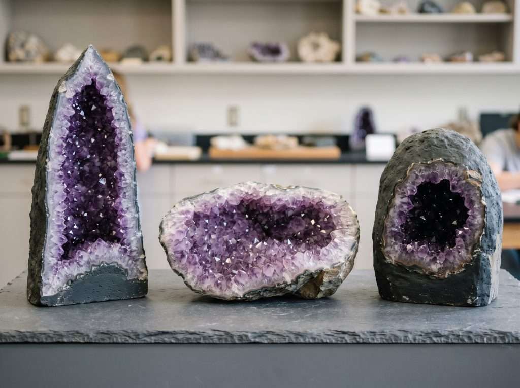 A diagram featuring three distinct amethyst crystal cave shapes: a cathedral geode, a half geode, and a freestanding cave formation for comparison.